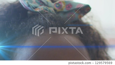Image of light trails over african american schoolgirl Image of light trails over african american schoolgirl 129579569