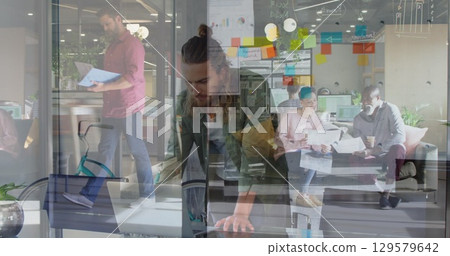 Image of people in office over caucasian man using laptop 129579642