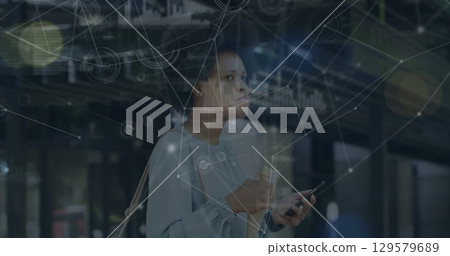 Image of network of connections and data over woman using smartphone 129579689