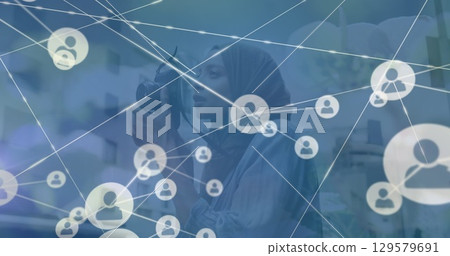 Image of network of connections with globe and icons over woman using camera 129579691