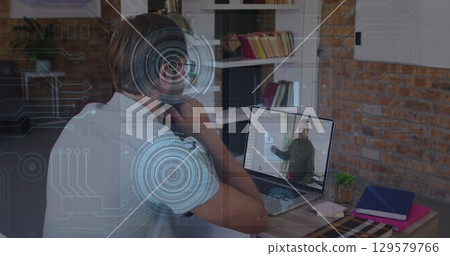 Image of data processing over caucasian male teacher having a image call on laptop 129579766