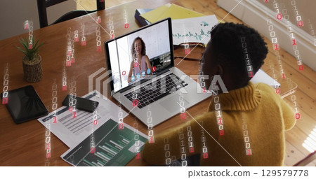 Image of binary coding over african american woman having a image call on laptop at home Image of binary coding over african american woman having a image call on laptop at home 129579778