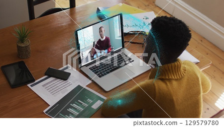 Image of spinning globe over african american woman having a image call on laptop at home Image of spinning globe over african american woman having a image call on laptop at home 129579780
