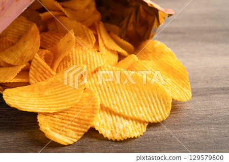 Potato chips, delicious BBQ seasoning spicy for crips, thin slice deep fried snack fast food in open bag. Potato chips, delicious BBQ seasoning spicy for crips, thin slice deep fried snack fast food in open bag. 129579800