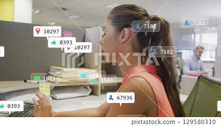 Image of social media notifications processing data over caucasian woman working at office desk 129580310