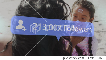 Image of increasing followers over mother and daughter playing at the beach 129580460