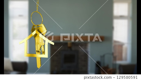 Image of key with keychain in shape of house over living room interior Image of key with keychain in shape of house over living room interior 129580591
