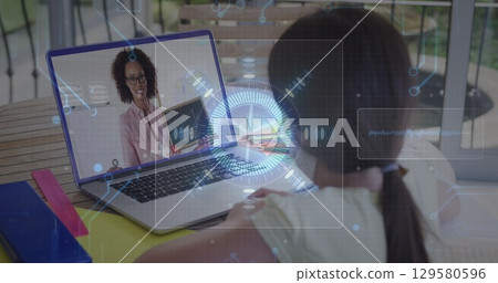 Image of round scanner and microprocessor connections against girl having a image call on laptop Image of round scanner and microprocessor connections against girl having a image call on laptop 129580596