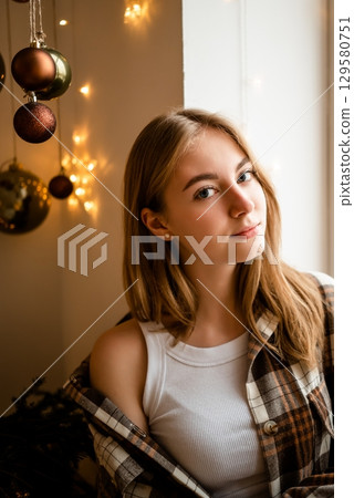 Young Woman in Cozy Attire with Festive Decor Young Woman in Cozy Attire with Festive Decor 129580751