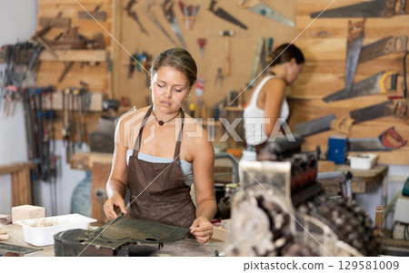 Girl is busy in carpentry workshop 129581009