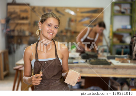 Girl is busy in carpentry workshop Girl is busy in carpentry workshop 129581013
