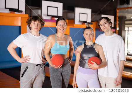 Group portrait of enthusiastic young people holding balls before upcoming jumping workout on trampoline in entertainment center Group portrait of enthusiastic young people holding balls before upcoming jumping workout on trampoline in entertainment center 129581023