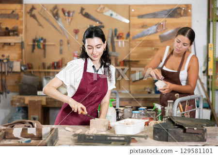 Girl working with wood in carpentry workshop Girl working with wood in carpentry workshop 129581101