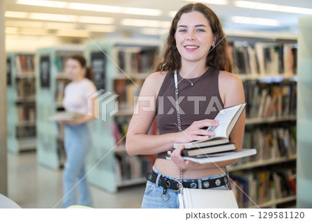 Female student with books on the background of shelves 129581120