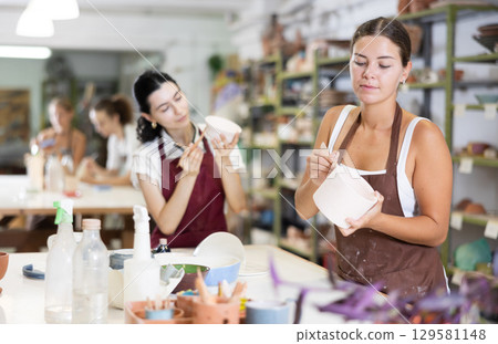 Girl performs polishing of ceramic product 129581148