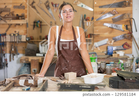 Girl is busy in carpentry workshop 129581184