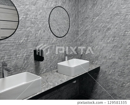 interior of toilet is in gray shades. gray and white. mirror, sink, toilet 129581335