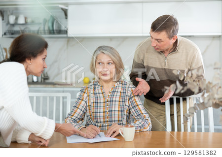 Old woman signing papers 129581382