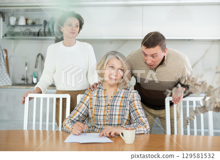 Old woman signing papers Old woman signing papers 129581532