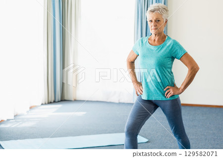 Senior woman in sportswear holding wide-legged pose on yoga mat in yoga studio, copy space Senior woman in sportswear holding wide-legged pose on yoga mat in yoga studio, copy space 129582071