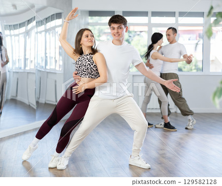 Young men and women dancing latin dances 129582128