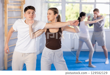 Young girl practicing self-defense techniques in pairs with guy 129582129