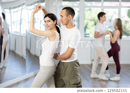 Young couple dancing playful bachata in choreography studio 129582131
