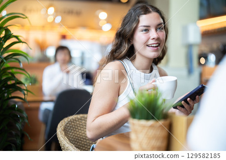 Young woman drinking coffee in cafe Young woman drinking coffee in cafe 129582185
