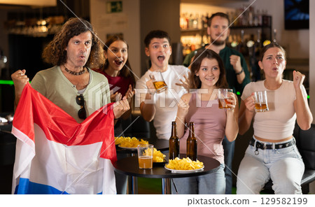 Fans of the Netherlands national team spend time in bar, shouting chants, supporting their favorite team 129582199