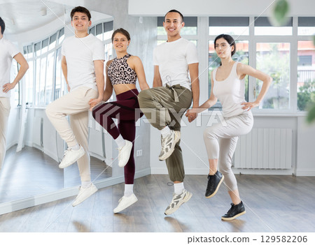 Group of young people stand in row holding hands, performing Irish folk dance. Group of young people stand in row holding hands, performing Irish folk dance. 129582206