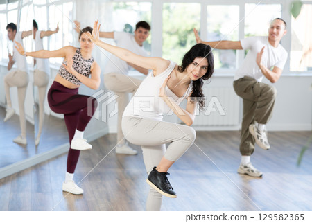 Cheerful brunette practicing energetic dance in choreography class 129582365