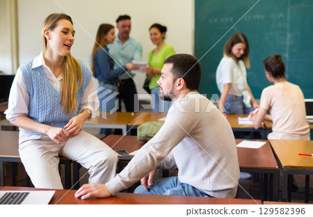 Man and woman students having small talk in classroom Man and woman students having small talk in classroom 129582396