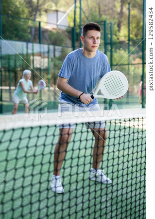 Man training to play tennis on padel court outdoor Man training to play tennis on padel court outdoor 129582434