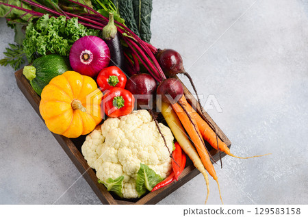 Fresh assorted vegetables in a wooden crate, showcasing vibrant colors and textures, perfect for healthy cooking and culinary inspiration 129583158