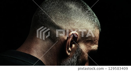 Hairdresser showing modern hairstyle on man in dark background 129583409