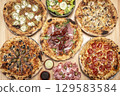 mixed different traditional italian pizzas on restaurant table 129583584