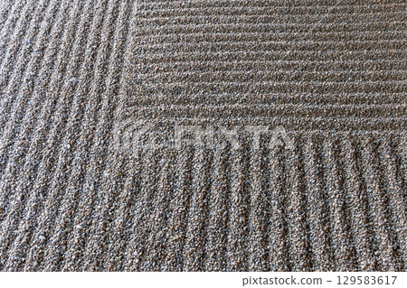 Raked gravel waves in karesansui garden zen landscape Raked gravel waves in karesansui garden zen landscape 129583617