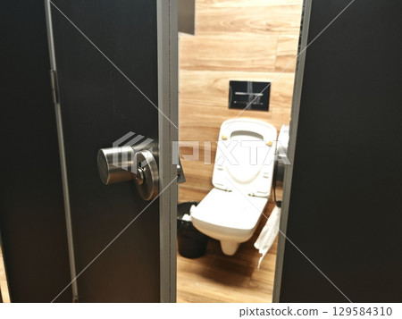 interior of toilet is in black shades. black and white. mirror, sink, toilet. black, public toilet 129584310