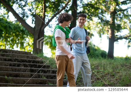 Two guys walking in the park and talking Two guys walking in the park and talking 129585644