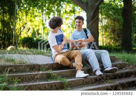 Two friends spending time together in the park after school 129585682