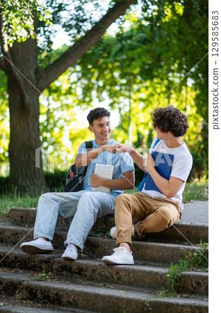 Two friends spending time together in the park after school Two friends spending time together in the park after school 129585683