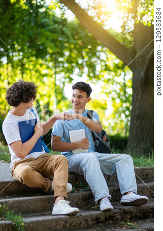 Two friends spending time together in the park after school 129585684