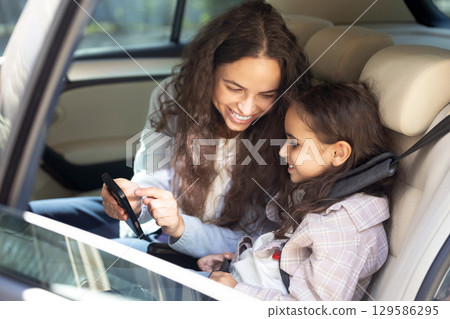 Mom and daughter in a car feeling happy and pleased 129586295