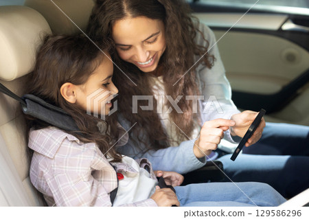 Mom and daughter in a car feeling happy and pleased Mom and daughter in a car feeling happy and pleased 129586296