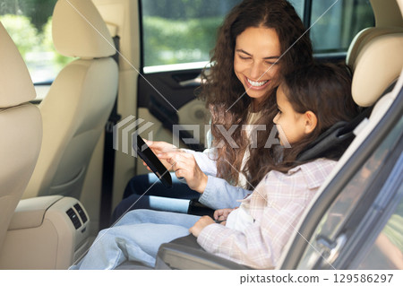 Mom and daughter in a car feeling happy and pleased 129586297