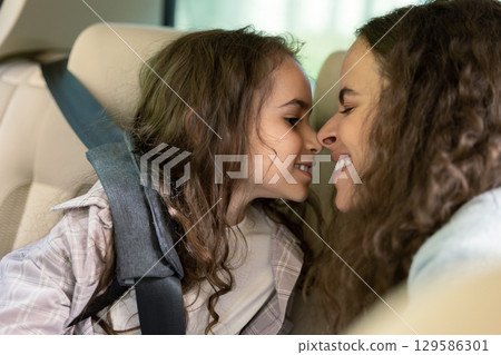 Mom and daughter in a car feeling happy and pleased 129586301