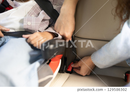 Close up picture of hands assembling safety belts in the car 129586302