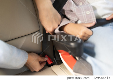Close up picture of hands assembling safety belts in the car 129586313