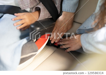 Close up picture of hands assembling safety belts in the car 129586314