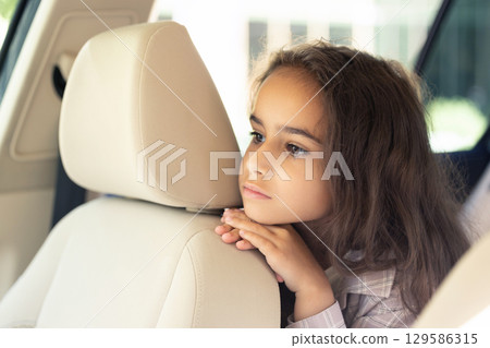 Long-haired sweet girl of school age in the care looking serious 129586315